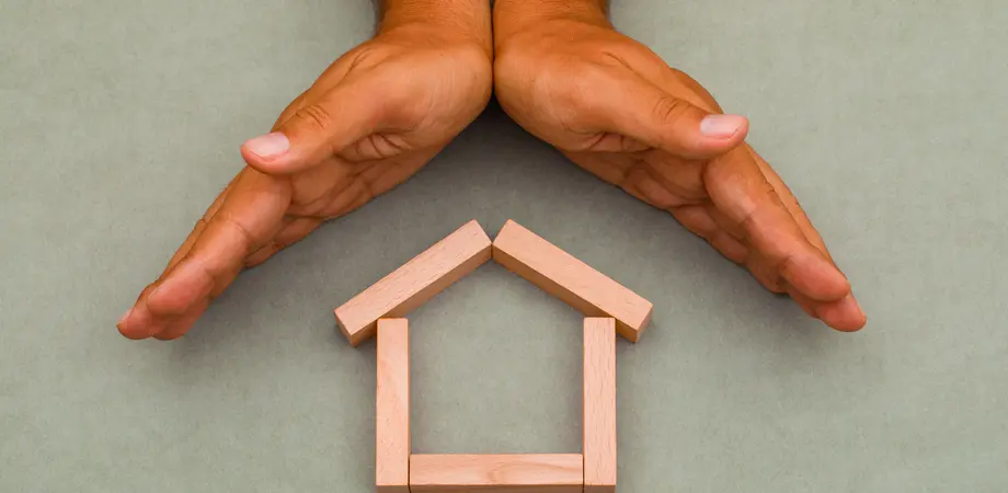 mains protégeants une maison