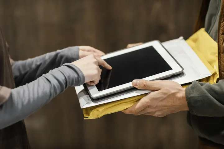 une personne signant électroniquement sur tablette