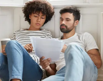 Couple qui s'informe sur l'encadrement des loyers