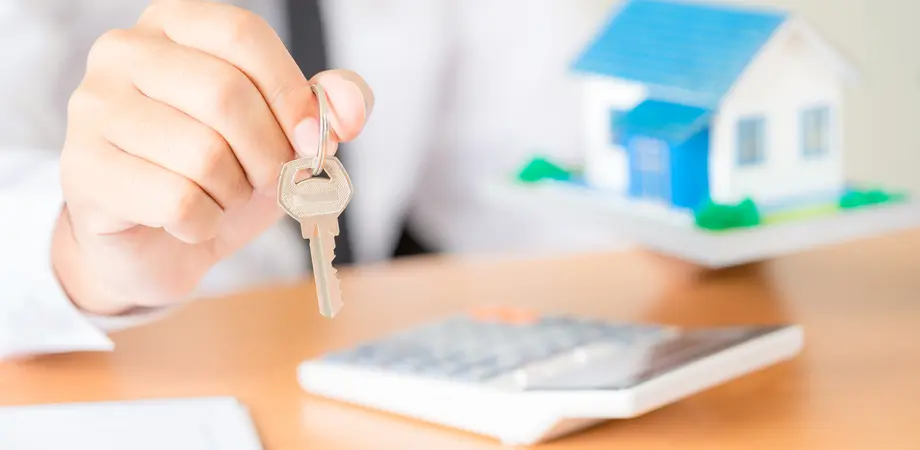 agent immobilier qui tend des clefs
