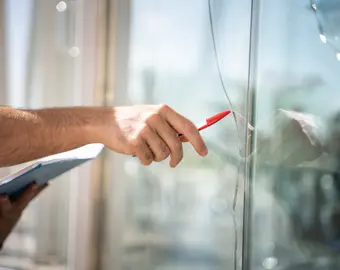 assureur pointant une vitre fissurée