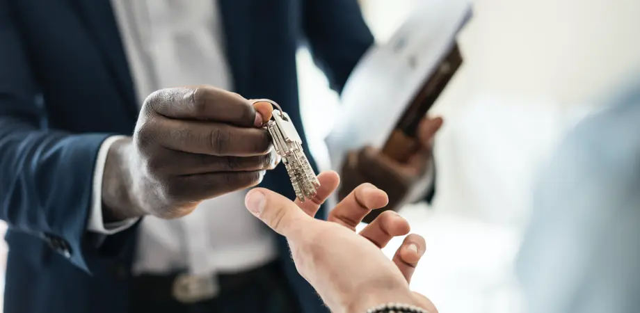 Un agent immobilier tend les clefs d'un appartment après un état des lieux d'entrée