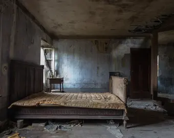 un lit défait après le départ d'un locataire