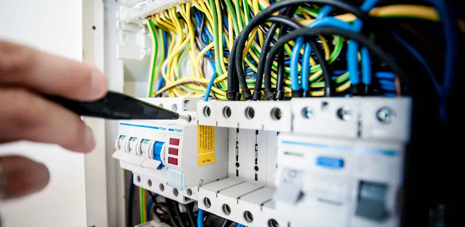 un technicien étudie le tableau électrique pour un diagnostic immobilier